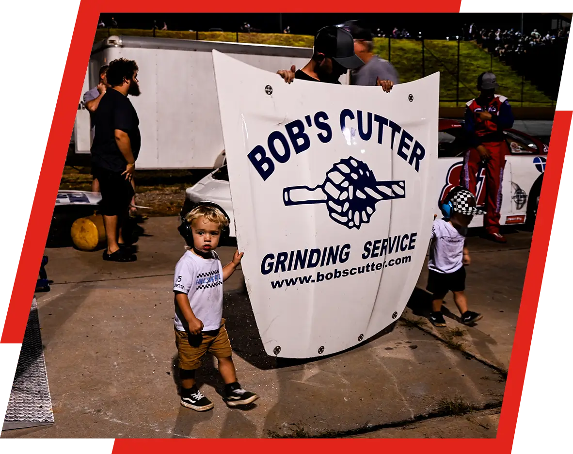 A group of people standing around with a sign.